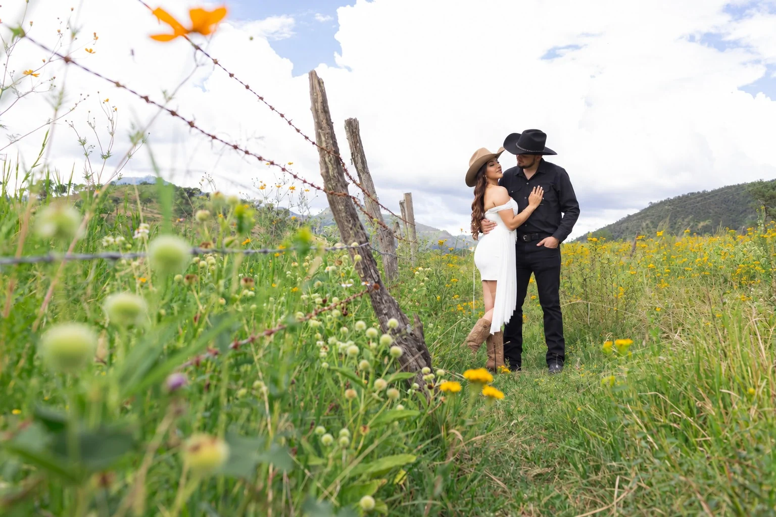 Magy y Carlos abrazados en un campo de flores